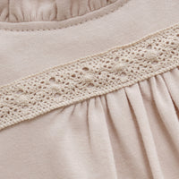 Close-up of beige fabric with lace trim and '3M' label.