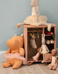 Children's toys and a small wooden cabinet against a light blue wall.
