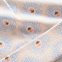 Close-up of a fabric with small floral patterns on a light background