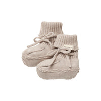 Pair of beige knitted baby booties on a white background