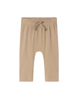 A pair of beige ribbed knit pants for toddlers, featuring an elastic waistband with a matching fabric bow, shown against a plain white background.