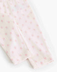 Close-up of a light pink fabric garment, likely a baby bodysuit or leggings, featuring a delicate all-over pink floral pattern and folded cuffs.