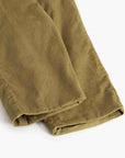 A close-up of olive green corduroy pants folded neatly on a clean white background, highlighting the textured corduroy fabric.
