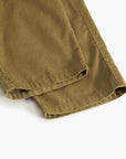 Close-up of folded olive green pants fabric on a plain white background.