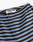 Close-up of a ribbed knit garment with horizontal brown and light blue stripes, showing a white neck label that reads 'MamMia'.