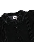 Black velvet garment with a visible brand label on a white background