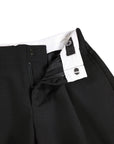Black pants with a white shirt collar and visible brand tag on a white background