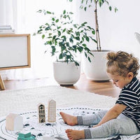 Child playing with toys on a rug in a bright living room
