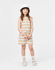 Young girl wearing a striped dress and bucket hat on a white background