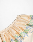 Beige shorts with floral embroidery on a white background