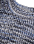 Close-up of a knitted sweater with a blue and gray pattern on a white background