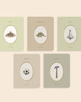 Five notebooks with oval illustrations on a beige background