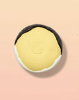 Yellow sponge with black rim on a beige background