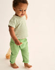 Child wearing a green and white striped shirt and green pants on a plain background