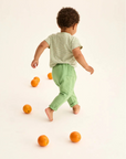 Child playing with oranges on a plain background