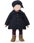 Doll wearing a dark coat, hat, and boots on a white background