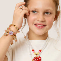 Young girl wearing a necklace with heart-shaped pendants on a plain background