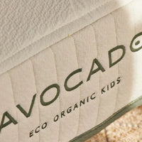 Close-up of a product with 'Avocado Eco Organic Kids' branding on a textured surface.