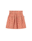 A children's pleated skirt with an elastic waistband, featuring a small-scale paisley pattern in coral pink, orange, and beige, shown flat on a light gray background.