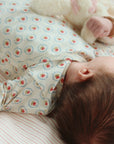 Baby wearing a floral onesie lying on a striped surface