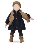 Doll wearing a navy dress with brown buttons, knitted scarf, and hat on a white background