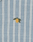 Blue and white striped fabric with a lemon embroidered on it