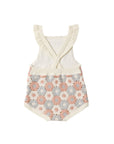 Baby romper with floral pattern and ruffled top on a white background