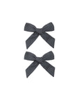 Two dark gray hair bows on a white background