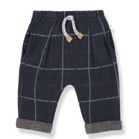 Navy plaid baby pants with a decorative bow on a white background