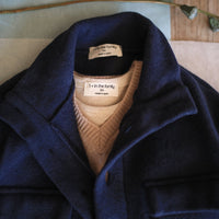 Navy blue coat with a brown vest and visible brand label on a neutral background