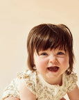 Child with a big smile on a beige background