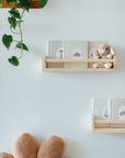 Wooden shelves with decorative items on a light blue wall.