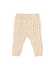 A pair of baby leggings with an all-over small floral print on a pale pink background, laid flat against a light gray studio background.