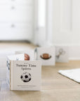 Children's book titled 'Tummy Time Sports' on a wooden surface with a blurred background