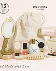 Set of makeup and beauty items with a drawstring bag on a light pink background, labeled 'Drawstring Included'.