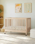 Nursery room with a wooden crib, white armchair, and ottoman.