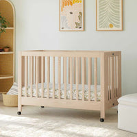 Nursery room with a wooden crib, white armchair, and ottoman.