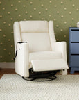 White recliner chair in a room with green wallpaper and a blue dresser.