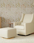 White armchair and ottoman in a room with floral wallpaper