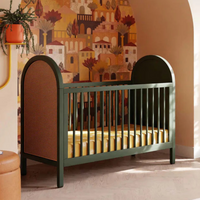 Nursery room with a green crib, decorative wall, and large window.