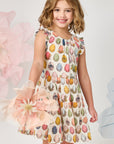 Young girl wearing a colorful dress with floral patterns against a light background