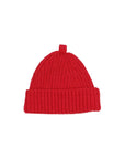 A bright red ribbed knit beanie hat with a folded cuff and a small top loop, photographed flat against a light gray background.