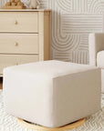Beige ottoman in a living room setting with a sofa and dresser.