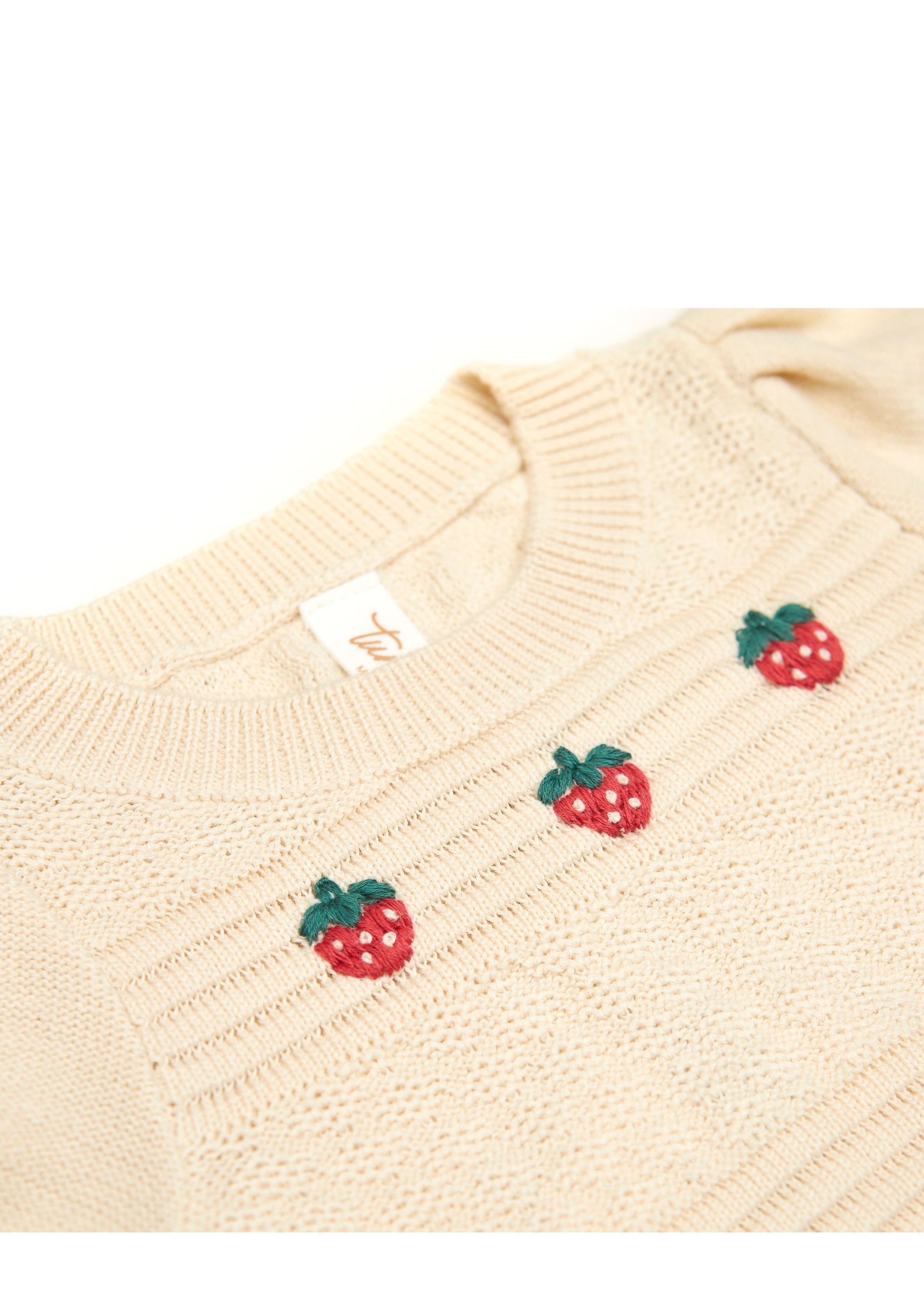 Beige sweater with strawberry embroidery on a white background