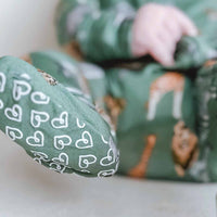 Green fabric with deer pattern and white heart designs on a light background