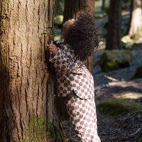 Child hugging a tree in a forest