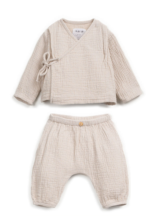 Beige baby outfit with top and pants on a white background