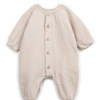 Beige baby onesie with button details on a white background