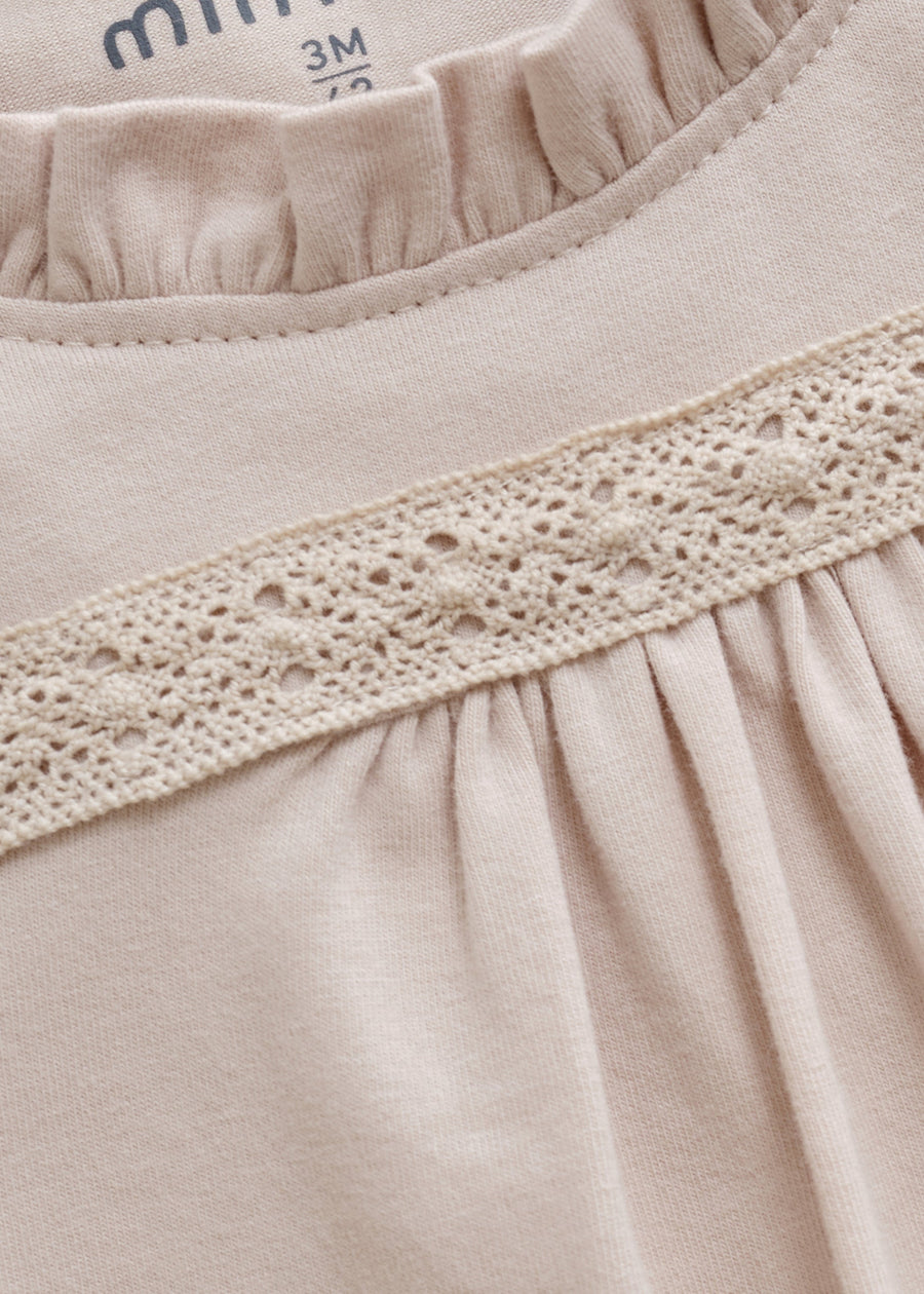 Close-up of beige fabric with lace trim and '3M' label.