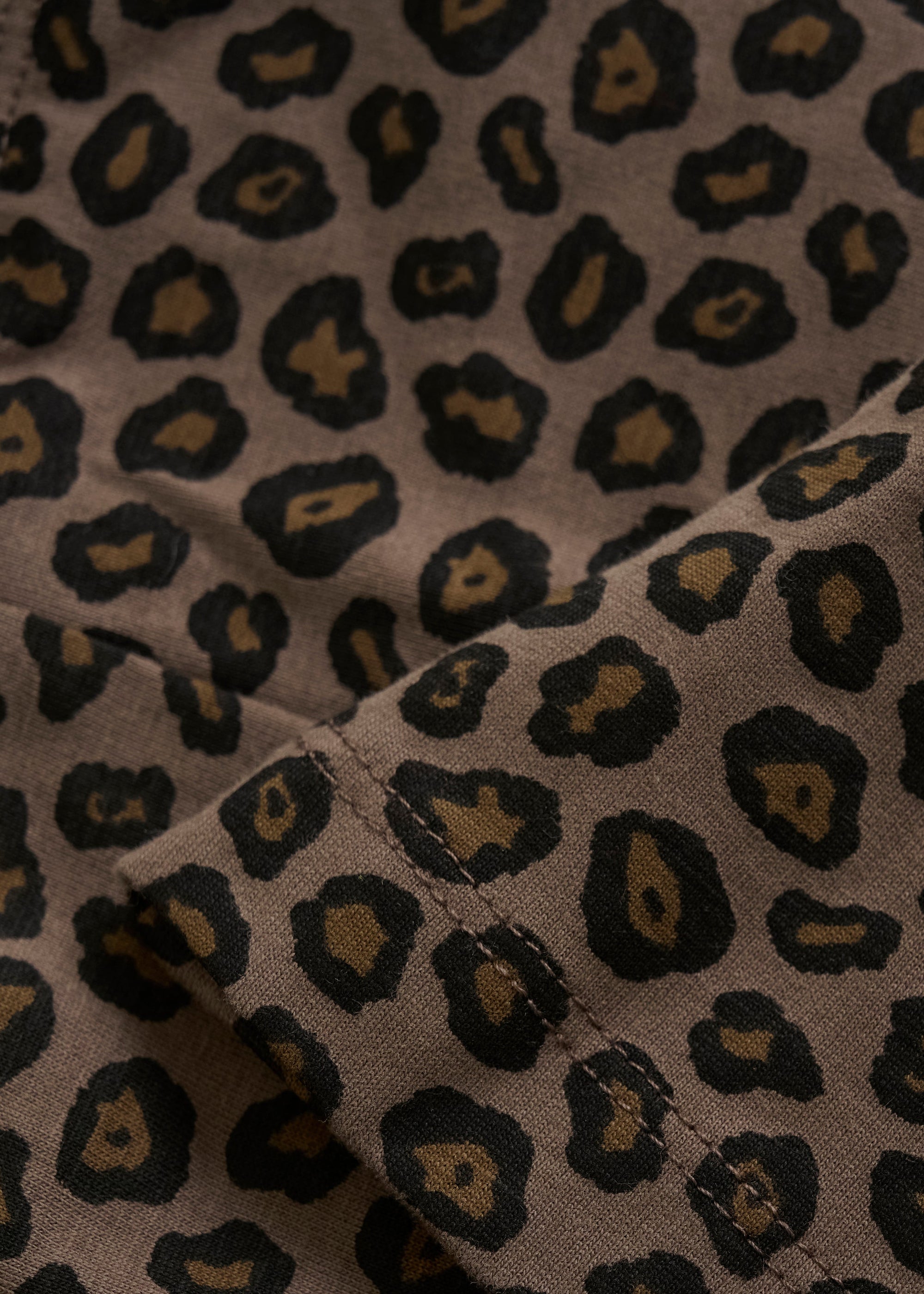 Close-up of fabric with a leopard print pattern on a beige background